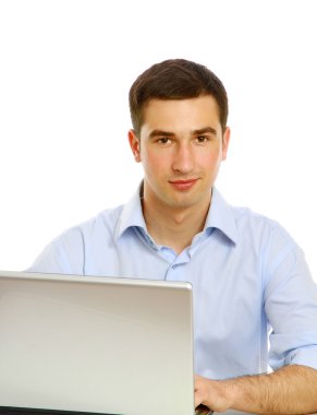 Adam dizüstü bilgisayarın önünde oturuyor.