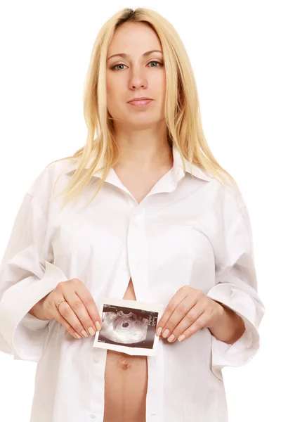 Pregnant woman holding an ultrasound picture of her baby — Stock Photo, Image