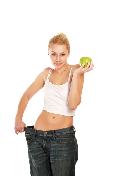 Chica joven con jeans grandes y manzana — Foto de Stock