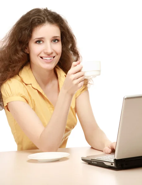 Mulher com uma xícara na frente de um laptop — Fotografia de Stock