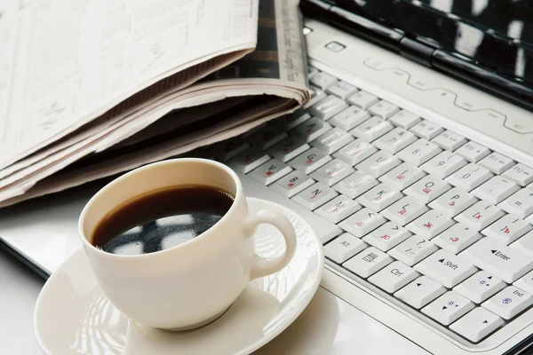 Tasse Kaffee, Morgenzeitung auf Laptop — Stockfoto