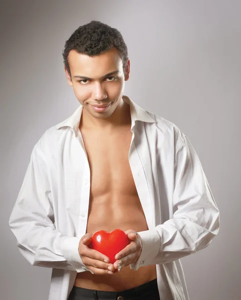 Młody człowiek posiadający czerwone serce — Zdjęcie stockowe