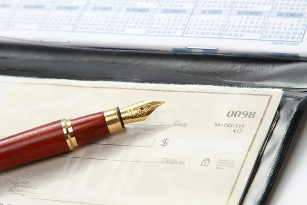 Open checkbook and a ballpen — Stock Photo, Image