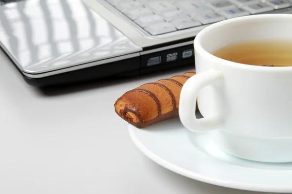 Computer portatile, tazza di tè e biscotti — Foto Stock