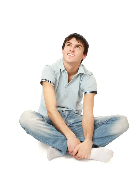Fundersam snygg ung man sitter på golvet — Stockfoto