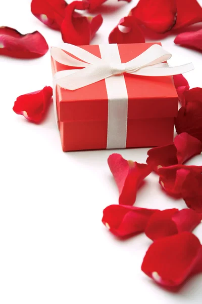 Gift and red rose petals — Stock Photo, Image