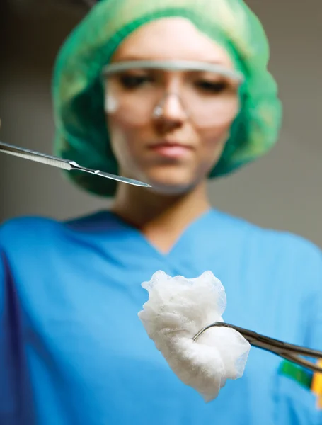 Mulher cirurgiã segurando instrumentos médicos — Fotografia de Stock