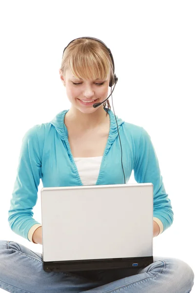 Girl with a headset working on the laptop — Stock Photo, Image