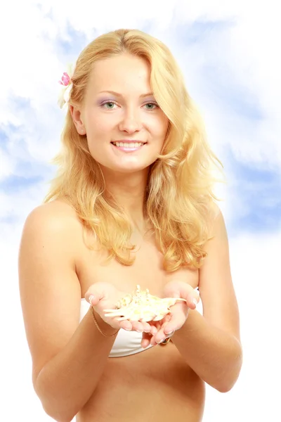 Woman on the beach holding a shell — Stock Photo, Image