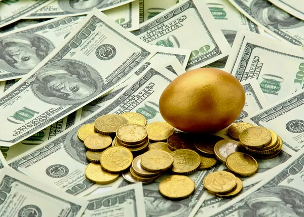 Guld ägg liggande på dollar — Stockfoto