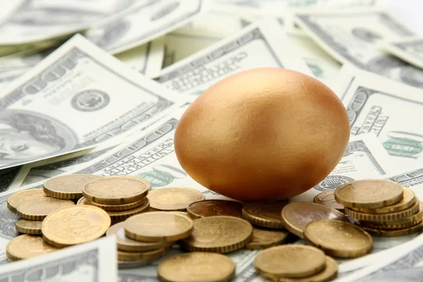 Gold egg lying on dollars — Stock Photo, Image