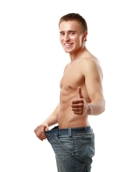 A muscular man showing how much weight he lost. — Stock Photo, Image