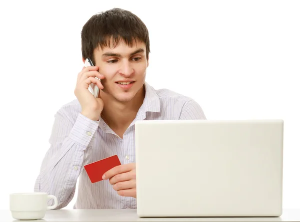 Un jeune homme avec une carte de crédit et ordinateur portable — Photo