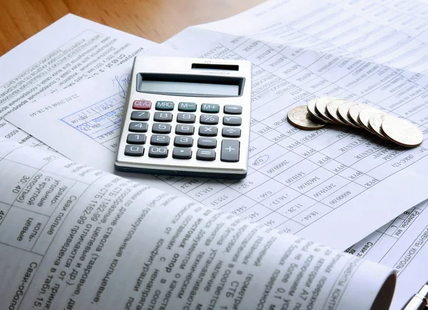 Moedas e calculadora em papel de negócios . — Fotografia de Stock