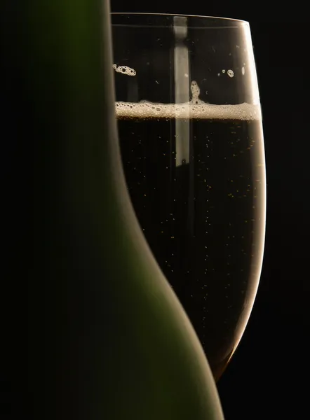 Элегантный бокал вина и бутылка вина на черном фоне . — стоковое фото