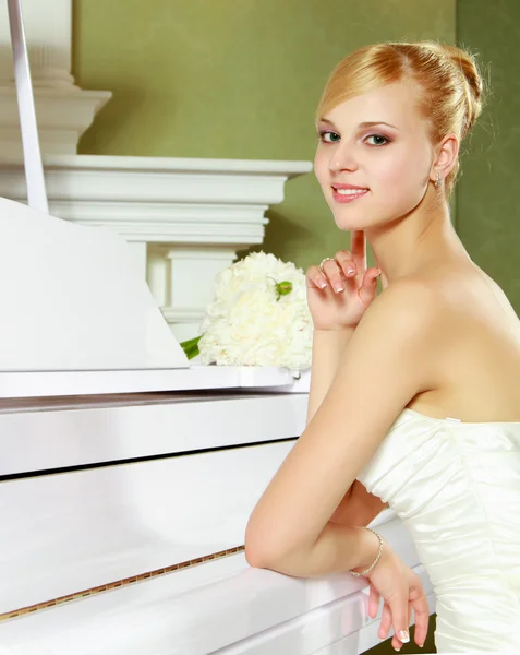 Beautiful, elegant bride by the piano. — Stock Photo, Image