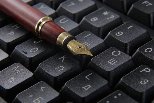 Pluma en el teclado del ordenador . —  Fotos de Stock