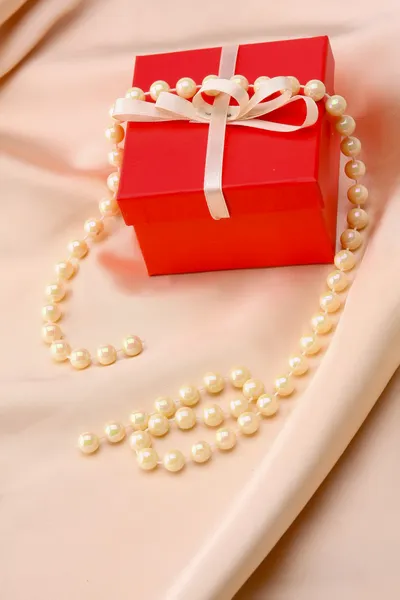 Gift on pink silk satin background. — Stock Photo, Image