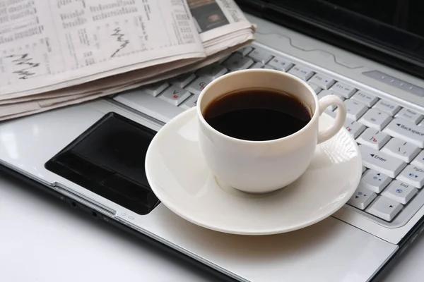 Kopje geurende koffie op een ochtendkrant — Stockfoto
