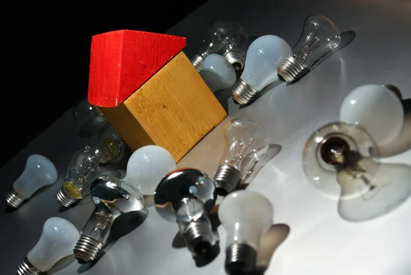 Light bulb and toy house. — Stock Photo, Image