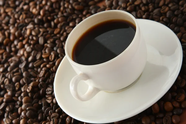 Kávová zrna s bílým cup. — Stock fotografie