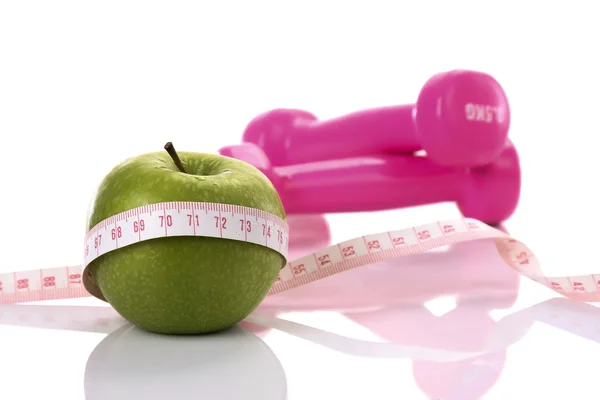 Tape measure with apple and pink dumbbels — Stock Photo, Image