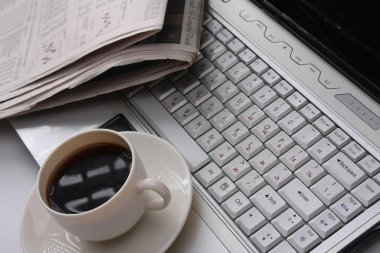 kahve fincanı, gazete ve dizüstü
