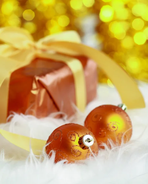 Goldene Weihnachtskugeln und Geschenk. — Stockfoto