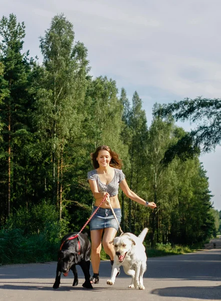 Mädchen läuft mit Hunden. — Stockfoto