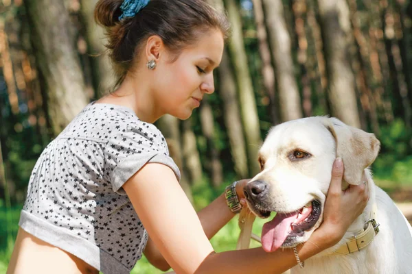 Meisje met haar hond rusten buitenshuis. — Stockfoto