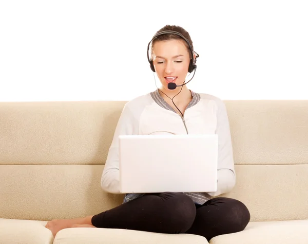 Girl with laptop sitting of a sofa. — Stock Photo, Image