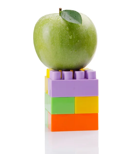 Multi-coloured details and apple — Stock Photo, Image