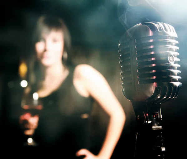Micrófono retro y una silueta femenina . — Foto de Stock