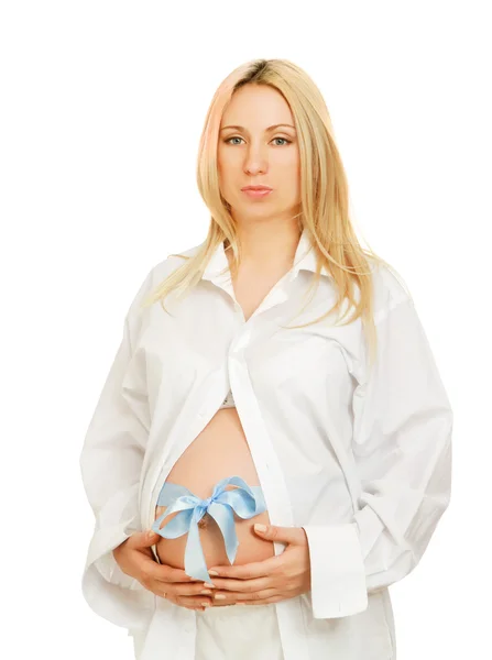 Беременная женщина с голубым бантом на животе — стоковое фото