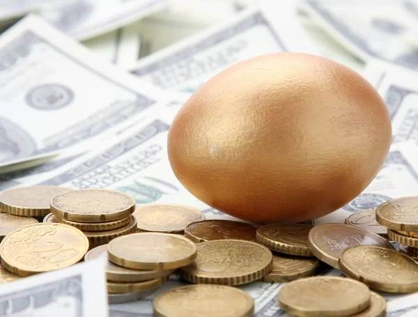 Gold egg lying on dollars — Stock Photo, Image