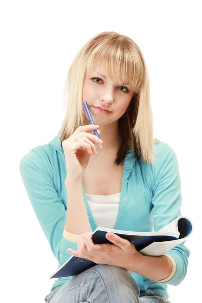 Chica con una pluma y un libro de texto —  Fotos de Stock