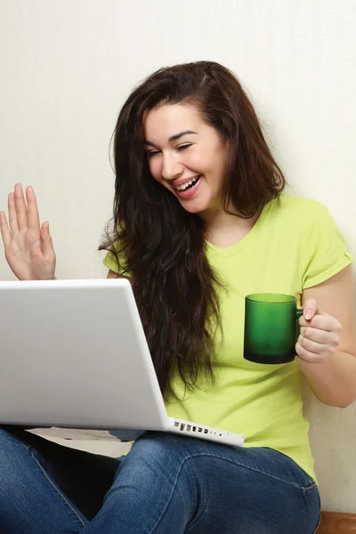 Flicka med laptop, håller cup — Stockfoto