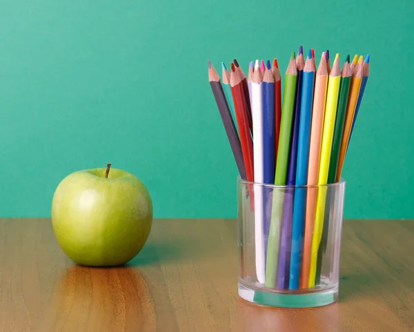 Pencils and green apple — Stock Photo, Image