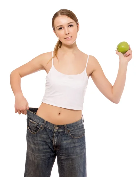 Молодая девушка в больших джинсах и яблоке Стоковое Фото