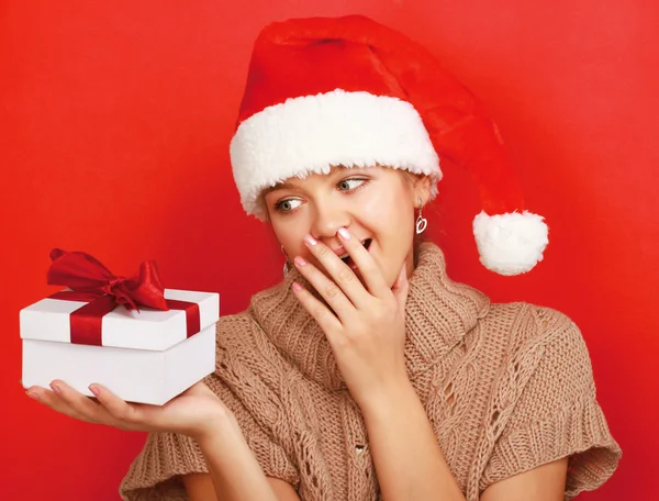 Woman on santa hat with christmas gift — Stock Photo, Image