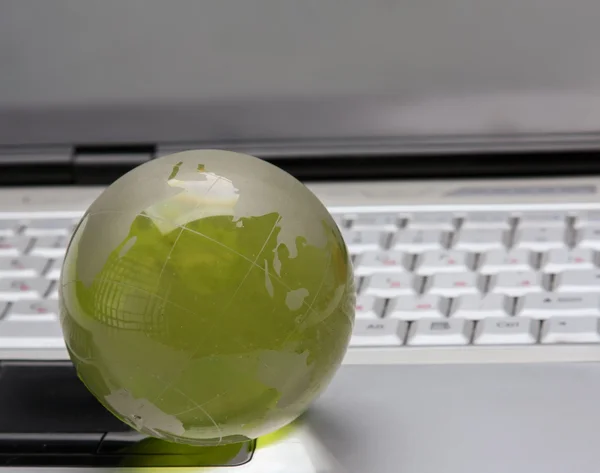 Стеклянный глобус на клавиатуре ноутбука — стоковое фото