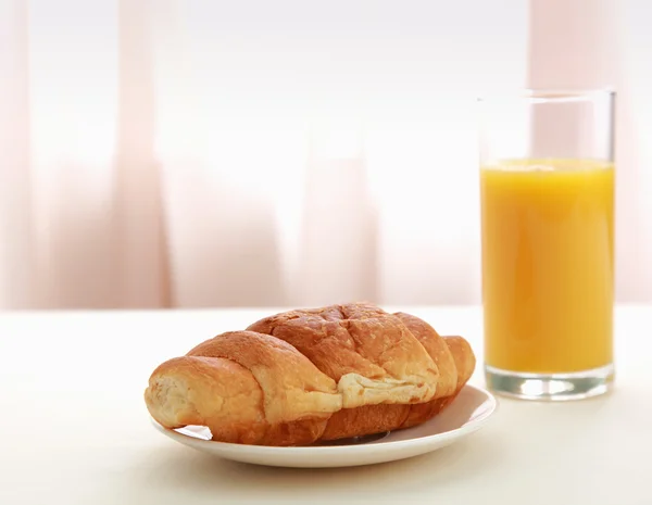 Oranje vruchtensap en croissant — Stockfoto