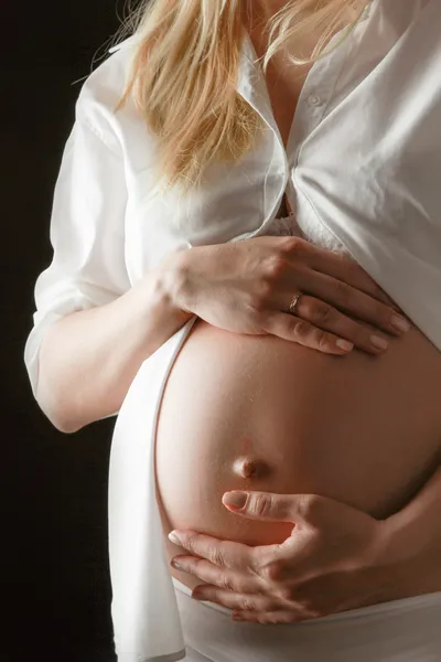 Uma mulher grávida segurando sua barriga — Fotografia de Stock