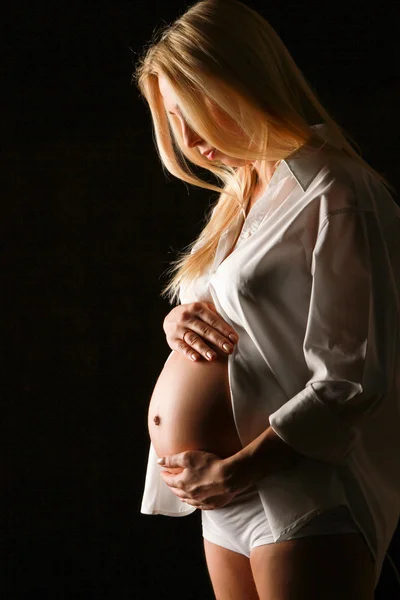 Een zwangere vrouw houden haar buikkobieta w ciąży, trzymając jej brzuch — Zdjęcie stockowe