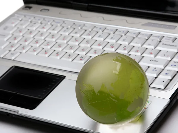 Globo de vidro em um teclado de laptop — Fotografia de Stock