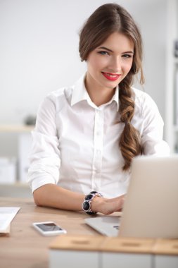 Ofiste masa başında oturan çekici bir iş kadını.