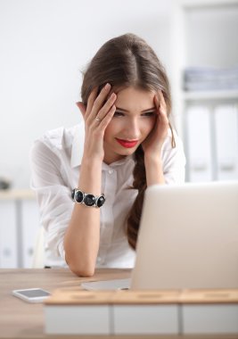 masada oturan bir laptop önünde yorgun kadın