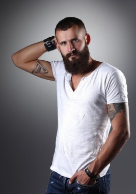 ayakta, gri arka plan üzerinde izole yakışıklı sakallı adam portresi