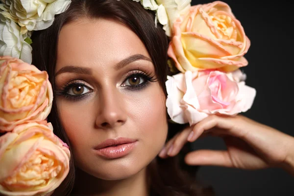 Retrato de uma mulher bonita com flores no cabelo. Foto de moda — Fotografia de Stock