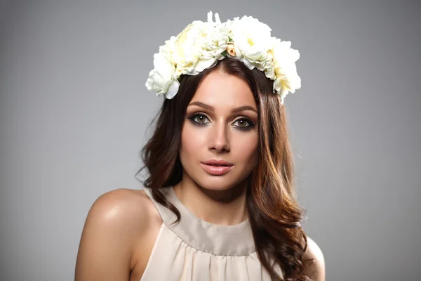 Retrato de uma mulher bonita com flores no cabelo. Foto de moda — Fotografia de Stock